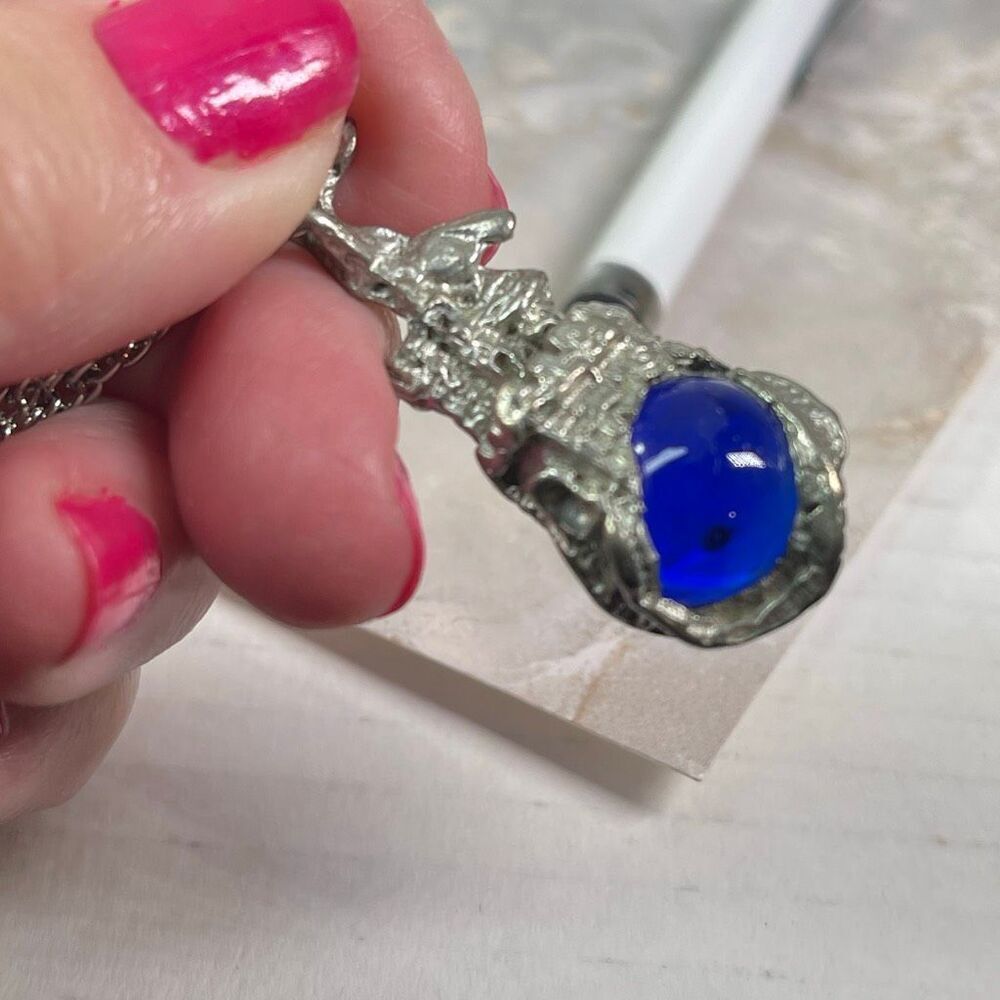 Vintage castle surrounding blue glass sphere. 24” stainless chain.